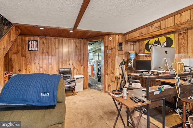 office space featuring carpet floors, wooden walls, and a textured ceiling