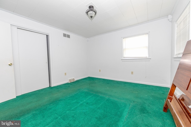 unfurnished bedroom featuring ornamental molding and carpet floors