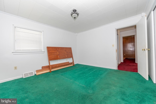 carpeted empty room featuring crown molding