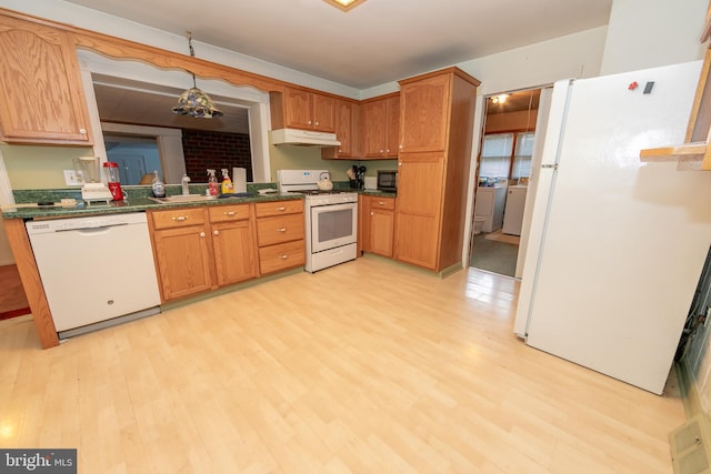 kitchen with white appliances, light wood-type flooring, and dark stone counters