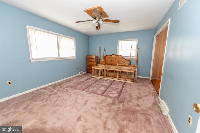 carpeted bedroom with multiple windows, ceiling fan, and a closet