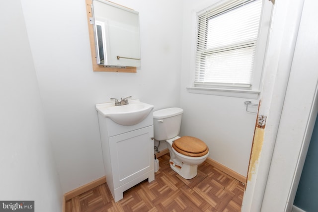 bathroom featuring vanity, parquet flooring, and toilet