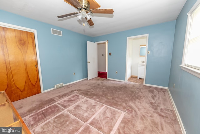 unfurnished bedroom featuring ceiling fan, a closet, ensuite bathroom, and carpet