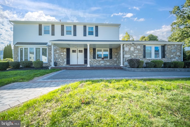 front of property featuring a porch and a front yard