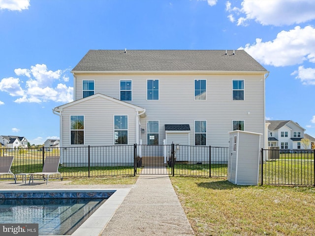 rear view of property with a fenced in pool and a yard