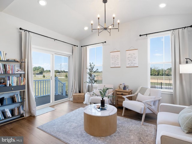 sitting room featuring an inviting chandelier, vaulted ceiling, hardwood / wood-style flooring, and a wealth of natural light