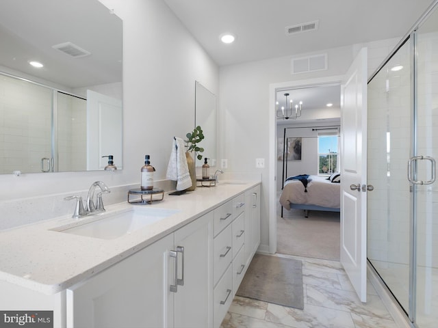 bathroom featuring a notable chandelier, vanity, and a shower with shower door