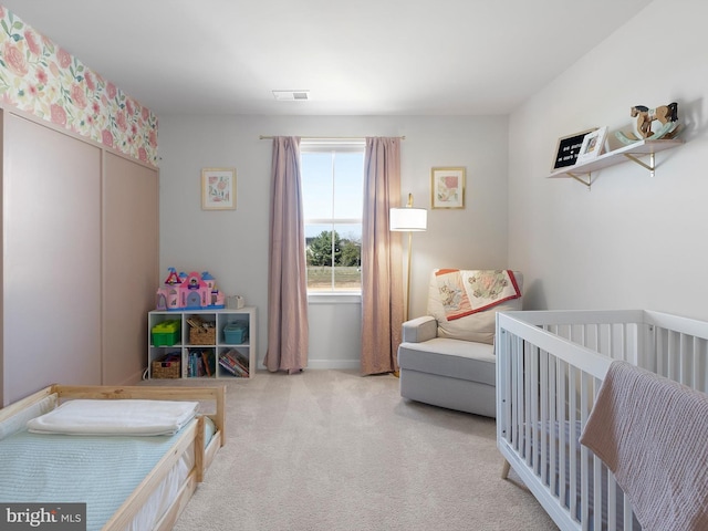 carpeted bedroom featuring a crib