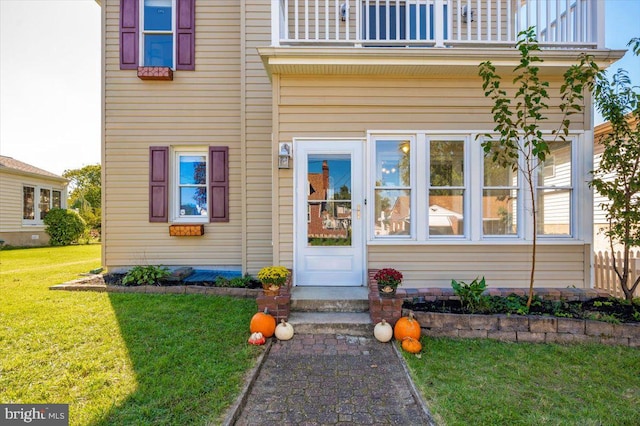 property entrance with a yard and a balcony