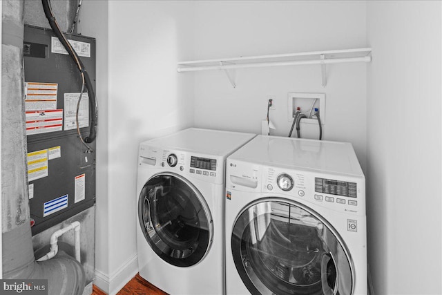 washroom featuring washing machine and clothes dryer, wood-type flooring, and heating unit