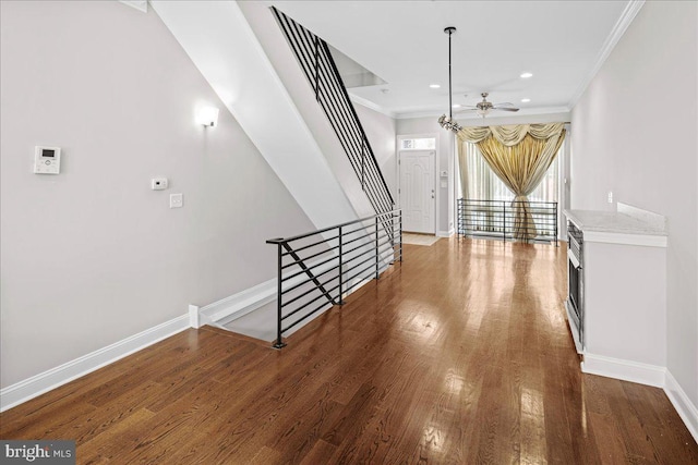 corridor with ornamental molding and dark wood-type flooring