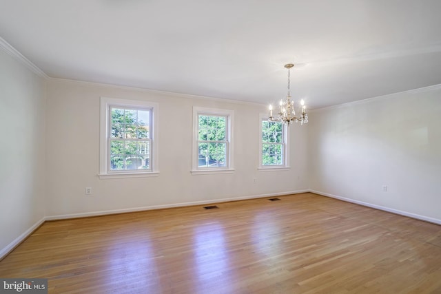 empty room with ornamental molding, light hardwood / wood-style floors, and a notable chandelier