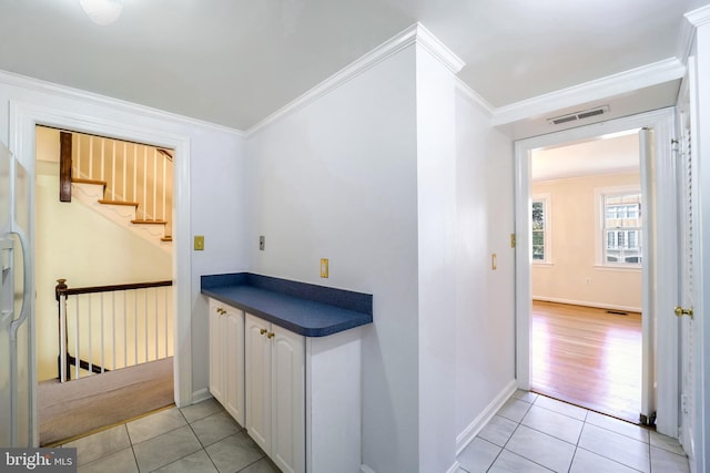 interior space with crown molding and light tile patterned flooring