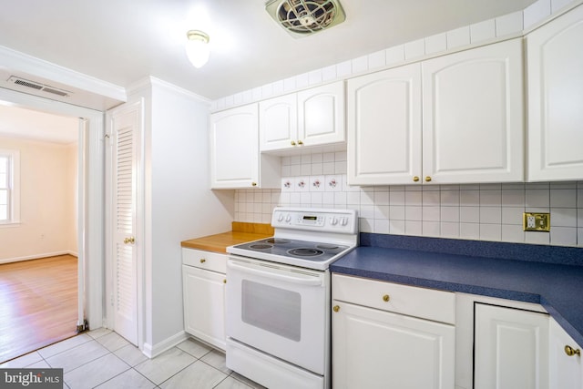 kitchen featuring electric stove and white cabinets