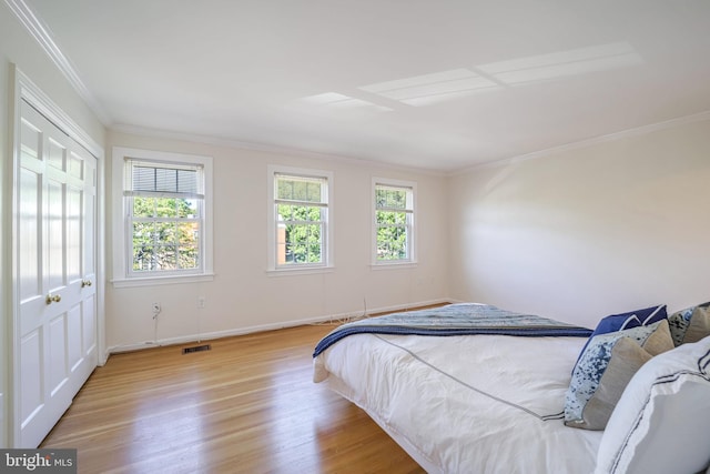 bedroom with light wood-type flooring and ornamental molding