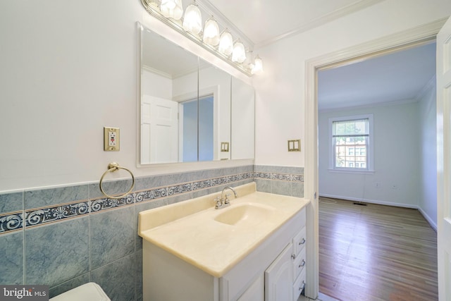 bathroom with hardwood / wood-style flooring, vanity, crown molding, and tile walls