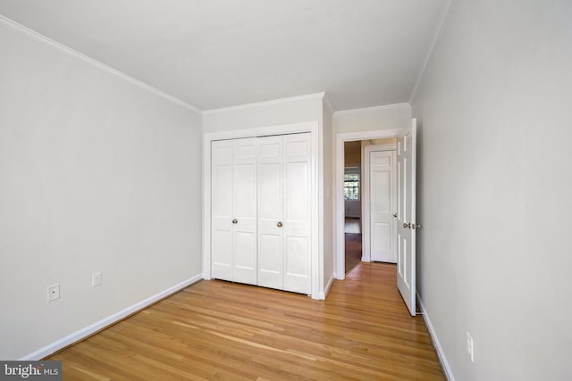 unfurnished bedroom featuring a closet, light hardwood / wood-style flooring, and ornamental molding