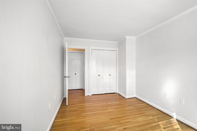 unfurnished bedroom with a closet, crown molding, and light hardwood / wood-style flooring