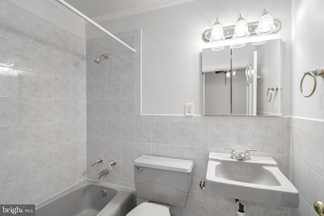 full bathroom featuring sink, tiled shower / bath combo, toilet, tile walls, and ornamental molding