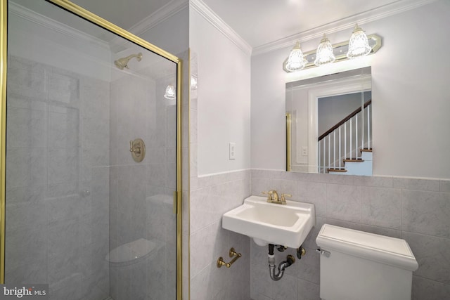 bathroom with crown molding, sink, tile walls, toilet, and a shower with shower door