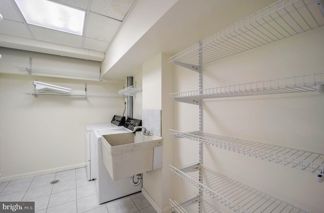 washroom featuring light tile patterned floors, sink, and washing machine and clothes dryer