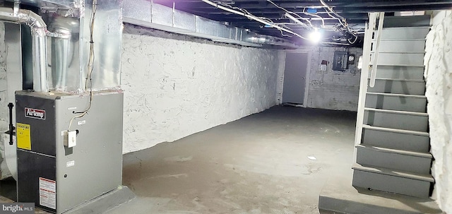 basement featuring heating unit and electric panel