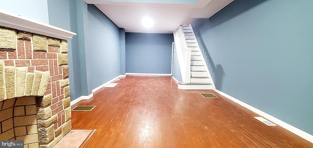 interior space featuring wood-type flooring and a stone fireplace