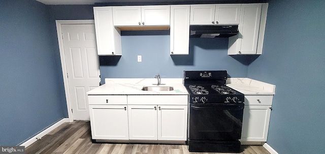 kitchen featuring black stove, ventilation hood, white cabinetry, and sink