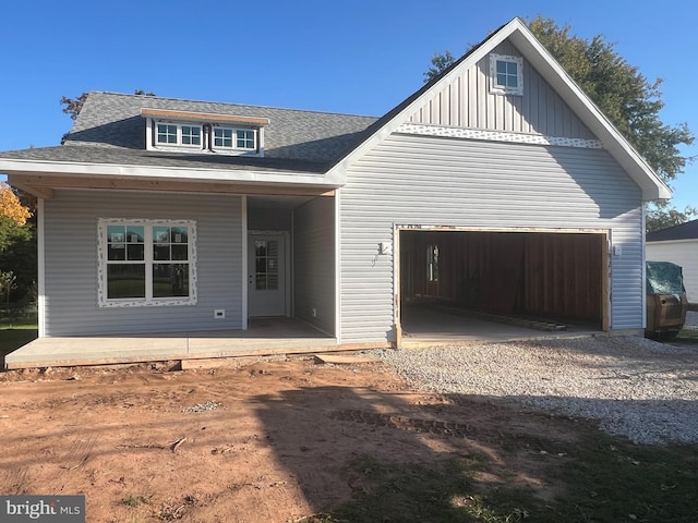 view of front of home featuring a porch, a garage, a shingled roof, driveway, and board and batten siding