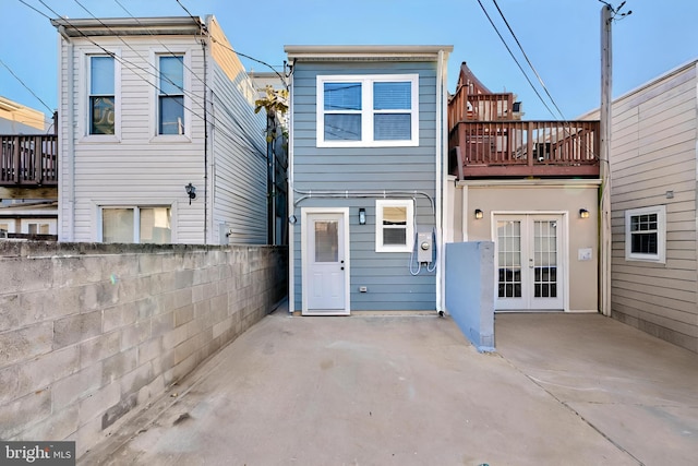 back of house featuring a balcony, french doors, and a patio area