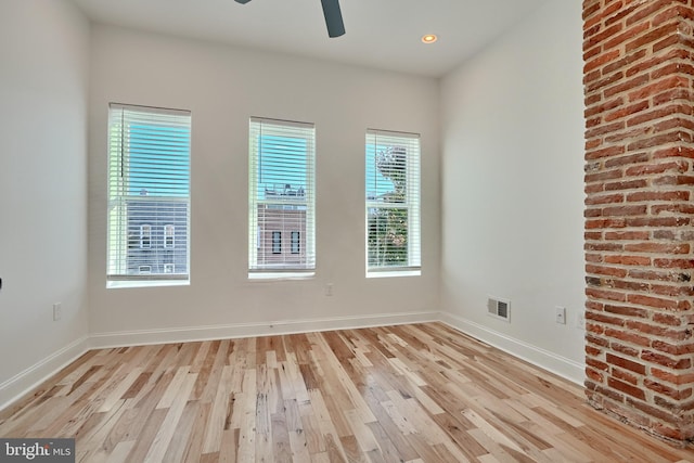 empty room featuring light hardwood / wood-style flooring, a healthy amount of sunlight, and ceiling fan