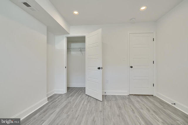 unfurnished bedroom featuring a closet and light wood-type flooring