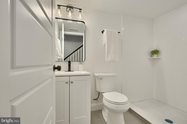 bathroom featuring vanity, toilet, a shower, and tile patterned floors