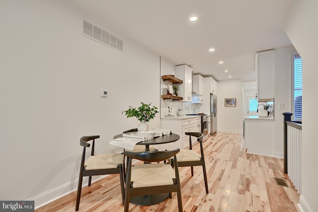 dining room featuring sink and light hardwood / wood-style floors