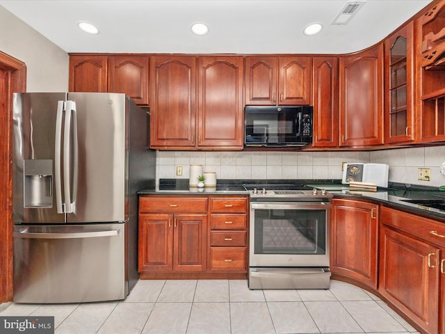 kitchen with decorative backsplash, light tile patterned floors, and stainless steel appliances