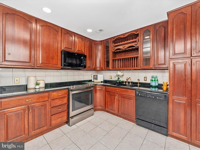 kitchen featuring black appliances, backsplash, light tile patterned floors, and sink