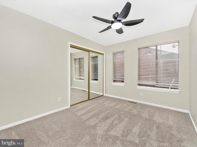 unfurnished bedroom featuring carpet flooring, a closet, and ceiling fan