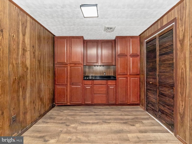 kitchen featuring light wood-type flooring and wood walls