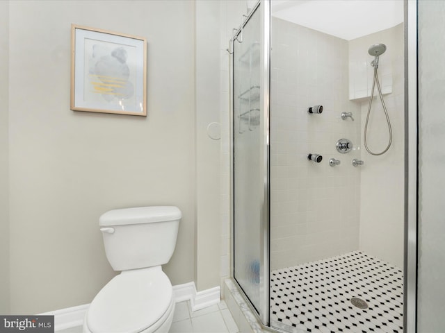 bathroom with a shower with door, tile patterned flooring, and toilet