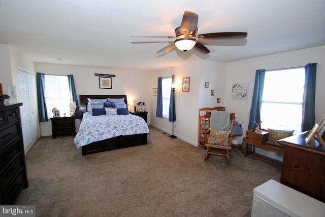 bedroom with multiple windows, ceiling fan, and carpet