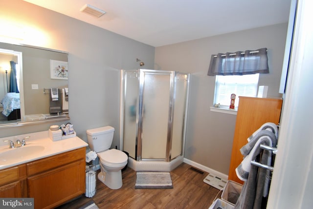 bathroom with hardwood / wood-style flooring, vanity, toilet, and a shower with shower door