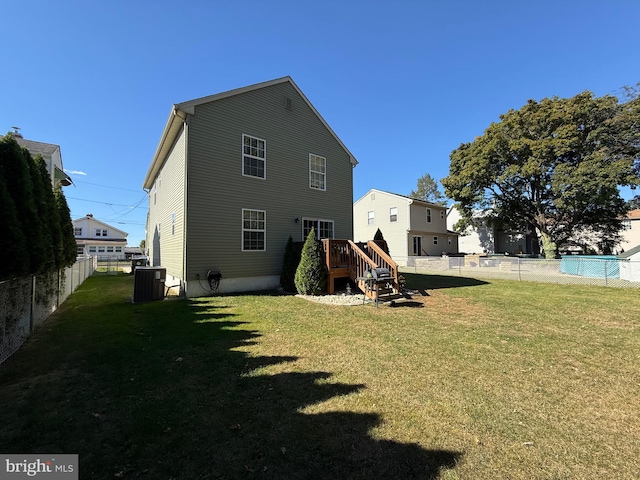 rear view of house featuring a yard and central AC