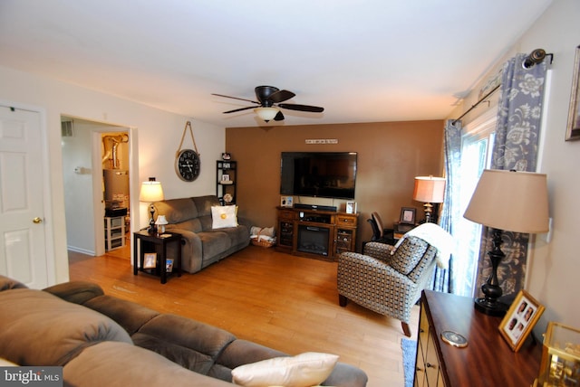 living room with wood-type flooring and ceiling fan