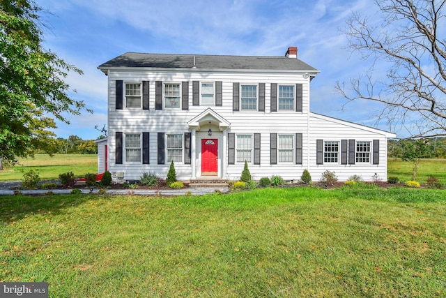 colonial inspired home with a front lawn