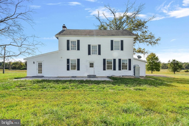 view of front of home with a patio and a front lawn