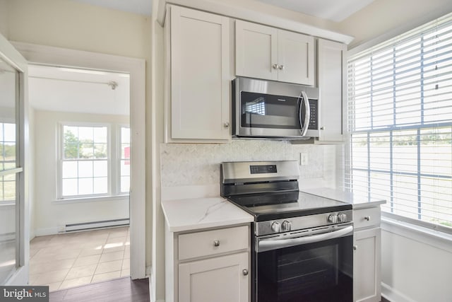 333 Carter Rd, Princeton, NJ 08540 - kitchen featuring appliances with stainless steel finishes, a baseboard heating unit, light stone counters, white cabinetry, and backsplash