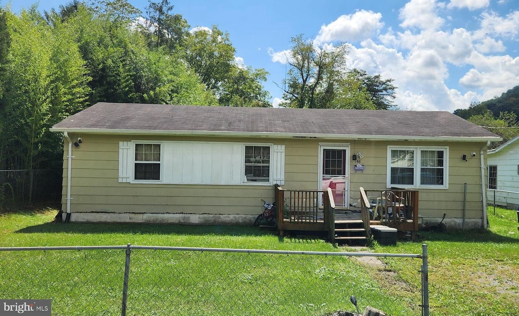 view of front facade with a front lawn and a wooden deck