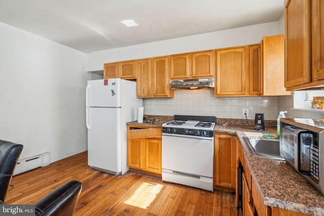 kitchen with sink, white appliances, backsplash, a baseboard heating unit, and hardwood / wood-style floors