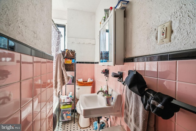 bathroom with sink and tile walls