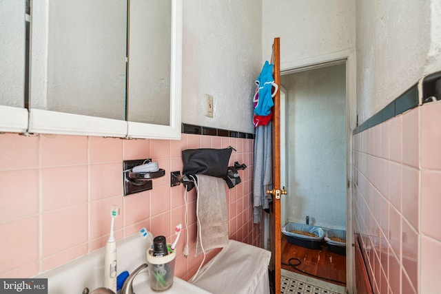 bathroom featuring hardwood / wood-style flooring and tile walls